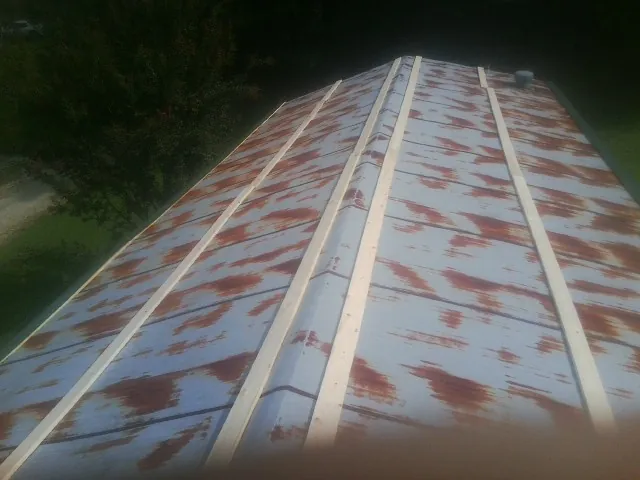 Rusted metal roof panels with new wood purlins before replacement — Storm Damage Roof Repair in Dighton by Roofing Brothers