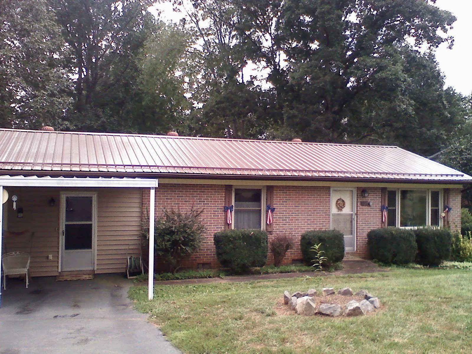 Bronze metal roof and carport on a brick ranch home — Roof Repair work by our crew in Dighton